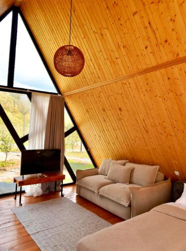 a living room with a couch and a tv at Zholovani Cottages in Lagodekhi