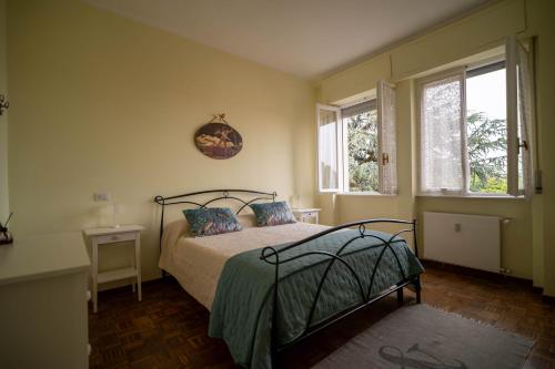 a bedroom with a bed and two windows at Casa Margherita in Vimercate
