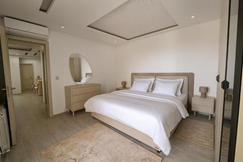 a bedroom with a large white bed and a mirror at Luxury 2 Bedroom Apartment Menzah 9C Near the airport in Tunis