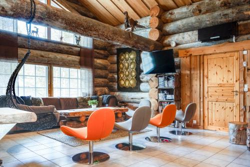 サッラにあるHoliday Log Villa Samruam Aの木製の壁のリビングルーム(テーブル、椅子付)