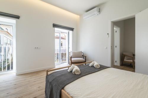 a bedroom with a bed with two towels on it at Downtown 1 Bedroom Apartment E - 150m from the Beach in Albufeira