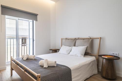 a bedroom with a bed with two towels on it at Downtown Studio Apartment F - 150m from the Beach in Albufeira