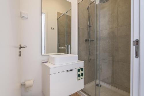 a bathroom with a sink and a shower at Downtown Studio Apartment F - 150m from the Beach in Albufeira