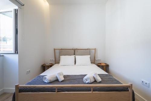 a bedroom with a bed with two towels on it at Downtown Studio Apartment G - 150m from the Beach in Albufeira