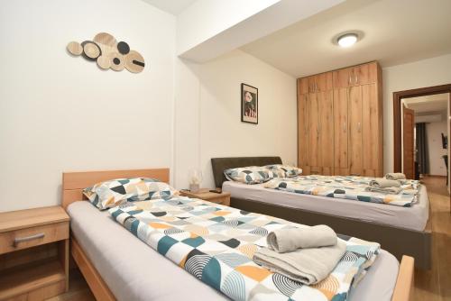 um quarto com 2 camas e um armário de madeira em Apartmani Resna Budva em Budva