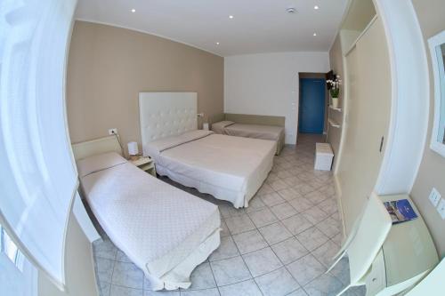 a hospital room with two beds and a mirror at Hotel Viña del Mar Pineta in Lido di Jesolo