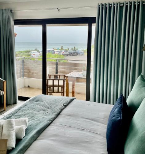 a bedroom with a bed with a view of the ocean at AtSupers Accommodation in Jeffreys Bay