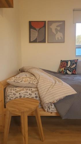 a bedroom with a bed and a wooden stool at על הגג במדבר in Mitzpe Ramon