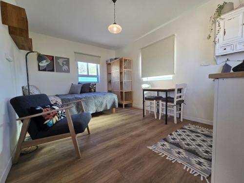 a bedroom with a bed and a desk and a table at על הגג במדבר in Mitzpe Ramon