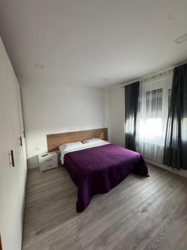 House 31 Plus في مونفالكوني: غرفة نوم بسرير وبطانية ارجوانية