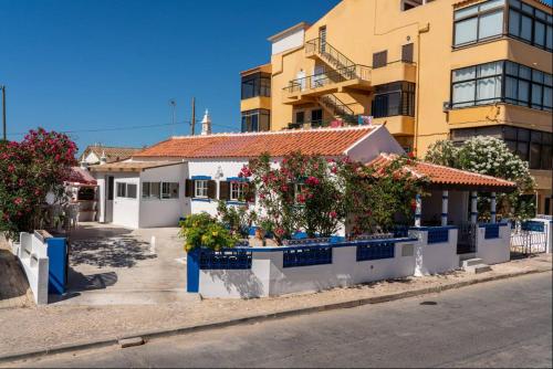a building with flowers on the side of a street at Blife Lucelya private rooms at Faro beach in Faro