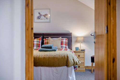 a bedroom with a bed with pillows and a mirror at Gwilym's Stable in Builth Wells