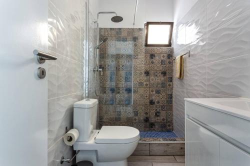 a white bathroom with a toilet and a shower at Blife Lucelya private rooms at Faro beach in Faro
