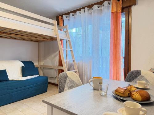 L'Orée du Parc في سان جيرفيه ليه بان: غرفة معيشة بها طاولة وسرير بطابقين