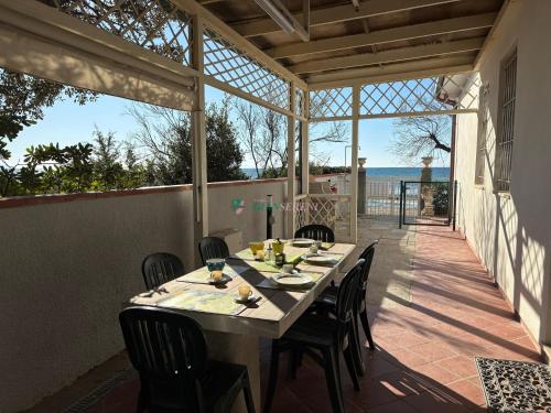a table and chairs on a patio with a view of the ocean at Casabianca in San Vincenzo
