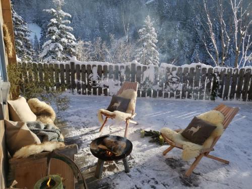 a yard with chairs and a fire in the snow at Rengerberg Hütte in Rengerberg