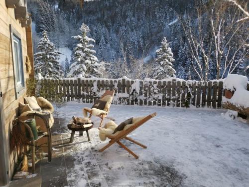 a snow covered yard with chairs and a fence at Rengerberg Hütte in Rengerberg