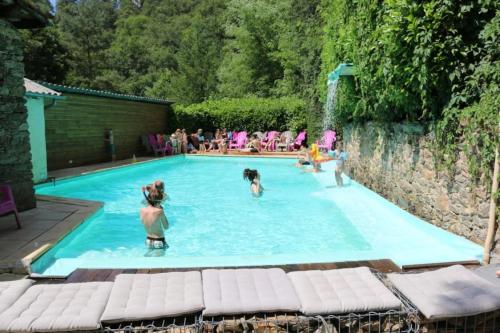 a group of people in a swimming pool at ZEcamping 3 étoiles avec piscine bar et restaurant en bord de ruisseau in Belguiral