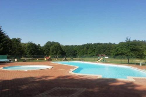 an empty swimming pool in a park with trees at Chalet 3 étoiles - Piscine - ccbbgcc in Sauxillanges
