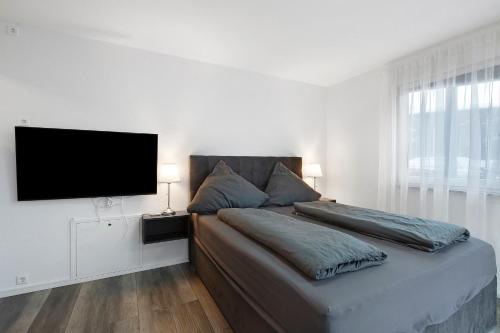 a bedroom with a large bed with a flat screen tv at Motel Ambiente 1 - Luxus Studio in Bad Säckingen