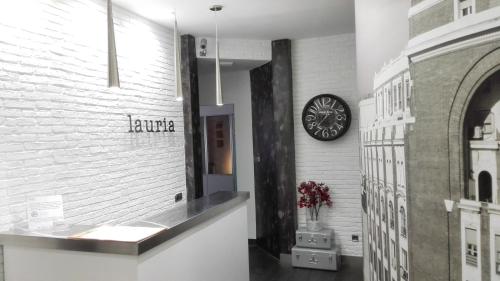 a hallway with a clock on a white wall at Hostal Lauria in Madrid