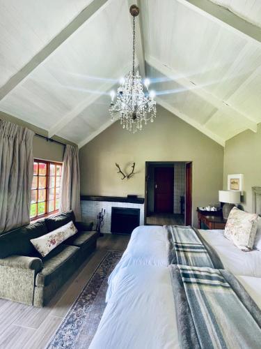 a bedroom with a large bed and a chandelier at Critchley Hackle - Tower rooms in Dullstroom