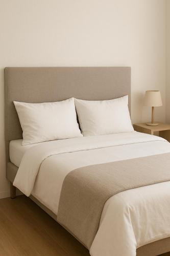 Fully Private Furnished Deluxe Studio Near Avenues Mall في مسقط: غرفة نوم بسرير كبير مع وسائد بيضاء