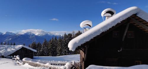 a snow covered house with two domes on top of it at Reh's Wiesen Hütte in Luson
