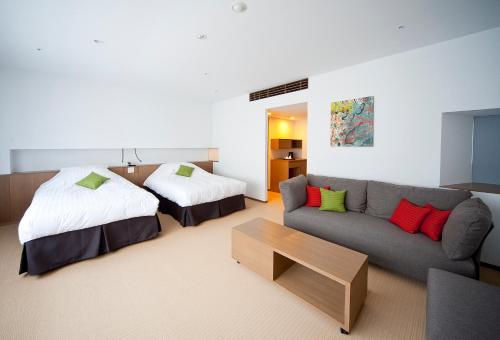 a hotel room with a couch and a bed at Kinosaki Onsen Nishimuraya Hotel Shogetsutei in Toyooka