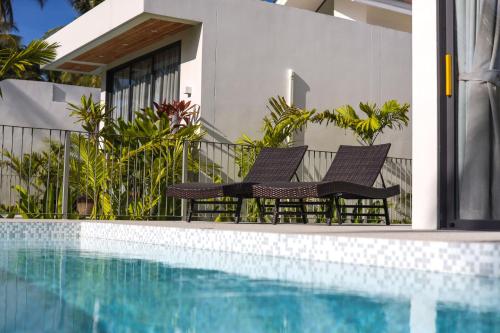 zwei Stühle neben einem Swimmingpool in der Unterkunft Modern Pool Villa Escape in Koh Phangan in Ko Phangan