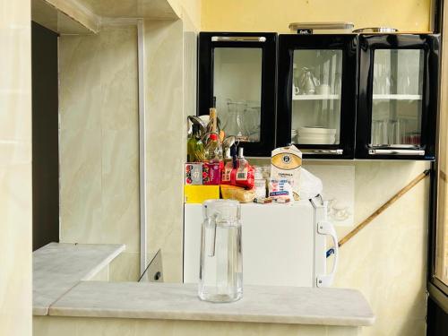 Apartamento Rua Rainha Ginga في لواندا: مطبخ مع ثلاجة بيضاء وخزائن سوداء