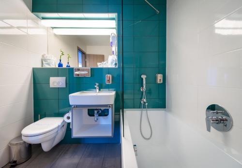 uma casa de banho com um WC, um lavatório e um chuveiro em Hotel Yacht Wellness & Business em Siófok