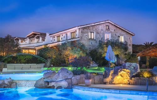 a house with a swimming pool in front of a house at Hotiday Baja Sardinia Saline in Cala Bitta