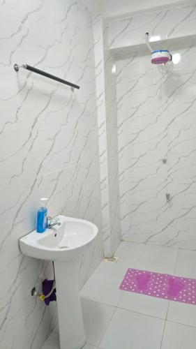 Un baño blanco con lavabo y ducha en Exciting, en Ongata Rongai 