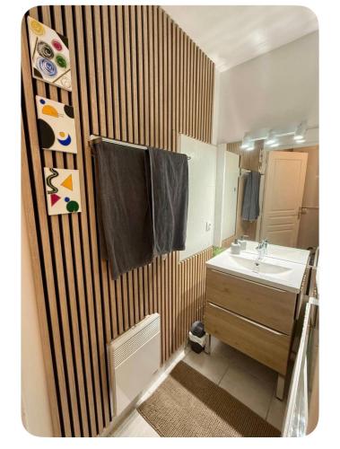 a bathroom with a sink and a mirror at La Perle - Jacuzzi Balneo- Wifi - Parking PV in Lunel
