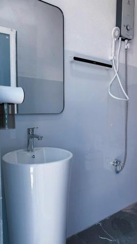 Cozy 2BR Retreat with Outdoor Living & Garden في دا نانغ: حمام أبيض مع حوض ومرآة