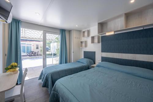 En eller flere senge i et værelse på Camping Village Torre Pendente