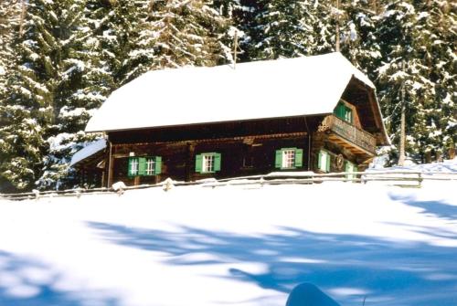 a log cabin with snow on the roof at Reinhoferhütte in Kasperle