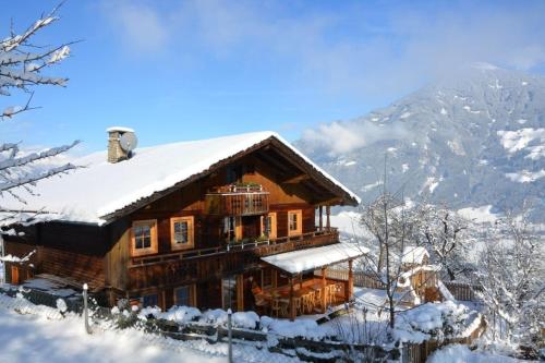 a log cabin with snow on the roof at Premium Chalet Zirbe in Emberg