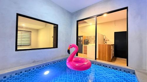a pink swan sitting in a swimming pool at Me'Lawwa Studio -Private Pool- in Kampung Padang Masirat