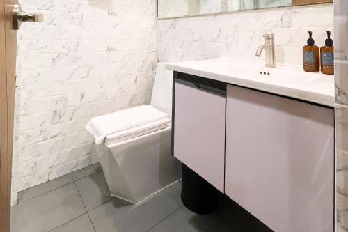 Un baño blanco con lavabo e inodoro. en Aberry Shore Resort La Union Hotel, 