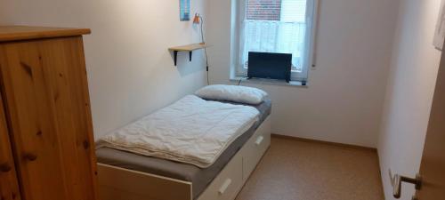 a small room with a small bed and a window at Nina in Norddeich