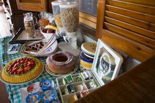 una tavola con torte e altri prodotti alimentari di Villa Ida Bed & Breakfast a Terracina