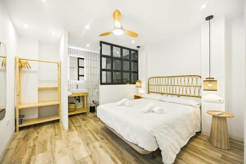 una camera da letto con un letto bianco e un pavimento in legno di Remedios 49 a Vejer de la Frontera