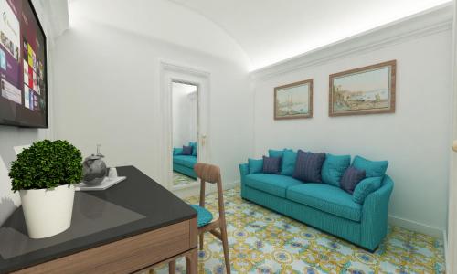 ein Wohnzimmer mit einem blauen Sofa und einem Tisch in der Unterkunft Palazzo Gargiulo Luxury Rooms & Suites in Sorrent