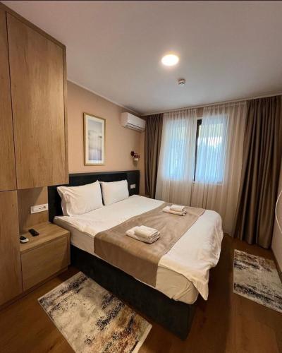 a bedroom with a large bed with two towels on it at Zlatibor Centar Lux Apartman in Zlatibor