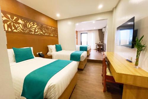 Una habitación de hotel con dos camas y un escritorio. en Aberry Shore Resort La Union Hotel, 