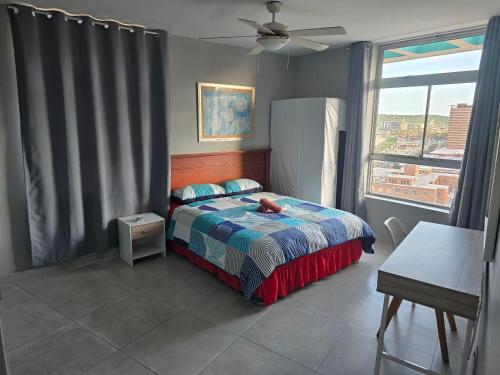 ein Schlafzimmer mit einem Bett und einem großen Fenster in der Unterkunft 12-0-ONE on 10 South Beach in Durban
