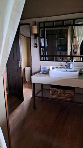 a bathroom with a white sink and a mirror at Mutara Camp- Nanyuki in Nanyuki