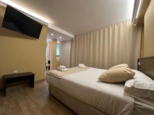 a hotel room with a bed and a flat screen tv at Hotel Santa Catalina by Bossh Hotels! in A Coruña